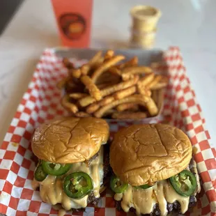 two burgers and fries on a tray