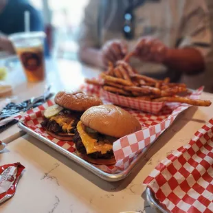a tray of hamburgers and fries on a table