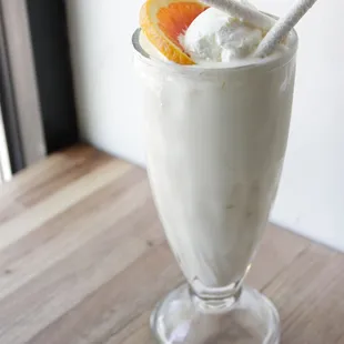 a milkshake with orange slices and whipped cream