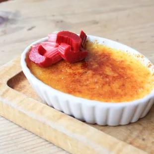 a bowl of creme with strawberries on top