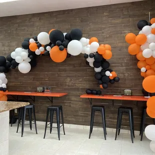an orange, white and black balloon arch