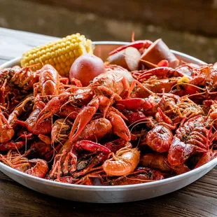 a bowl of crawfish, corn and potatoes