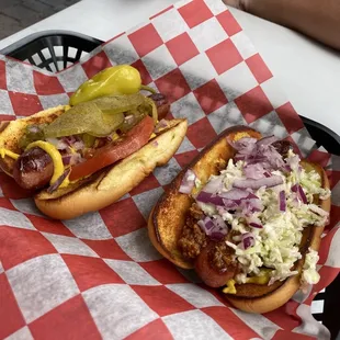 two hot dogs on a bun with coleslaw and pickles