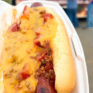 a hot dog covered in cheese and chili