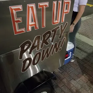 a woman standing next to a food cart