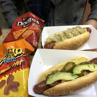 two hotdogs with guacamole and chips