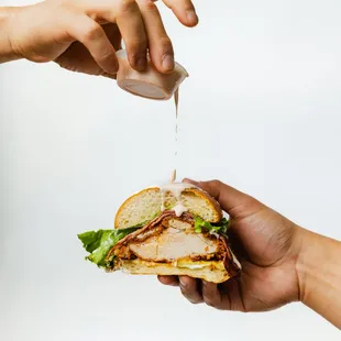 two hands holding a sandwich