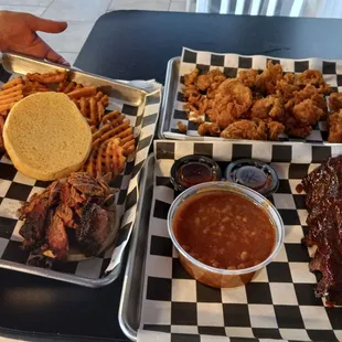 Brisket sandwich. Waffle fries. Fried pickles. Half rack ribs and baked beans.