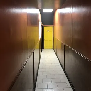 a hallway leading to a yellow door