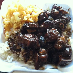 Oxtail with white rice and a side dish of macaroni and cheese