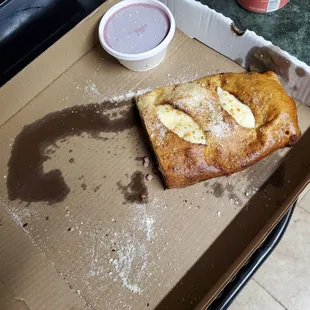 1/2 of a Stromboli inside a small pizza box