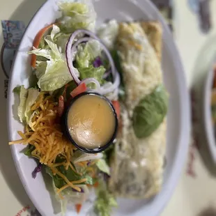 a plate of enchilada and salad