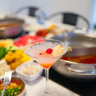 a martini with a cherry garnish in it