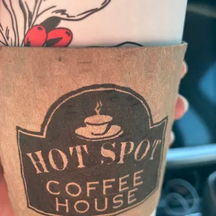 a hand holding a coffee cup