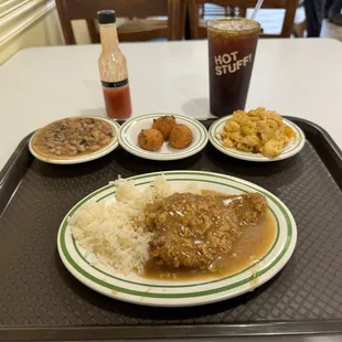 Chicken fried steak, rice, black eyed peas, hush puppies, Mac and cheese, homemade hot sauce, iced tea