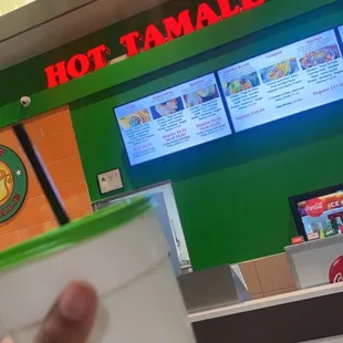 a hand holding a cup of hot tamale