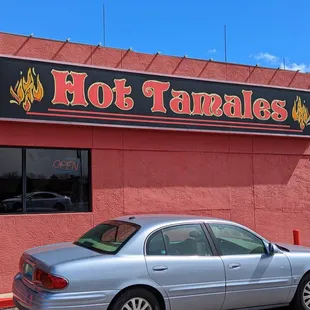 a car parked in front of a hot tamales restaurant