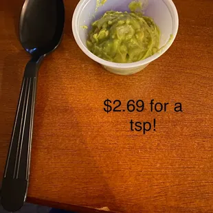 a bowl of guacamole and a spoon