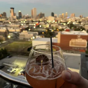 a person holding a glass with a drink in it