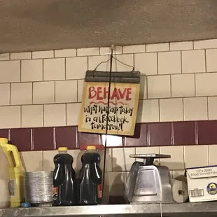 a sign on a shelf in a kitchen