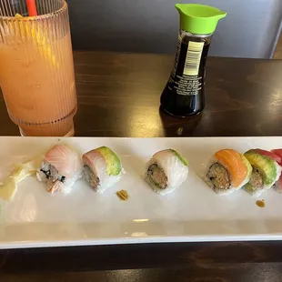 Half eaten rainbow roll with mai tai.