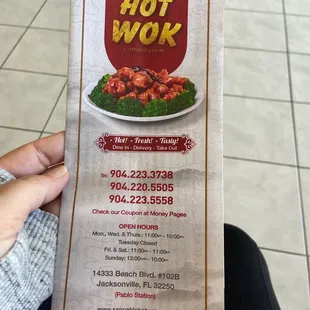 a person holding up a menu