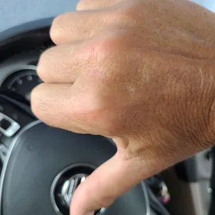 a hand on a steering wheel