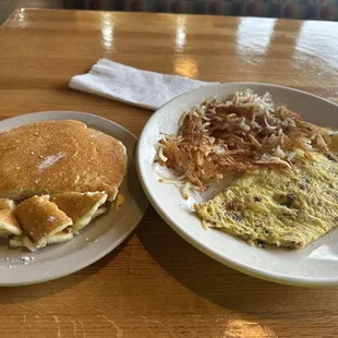12/02/2023 Hotcakes with a spinach, bacon Swiss omelette and hash browns.