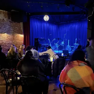 people sitting at tables in front of a stage