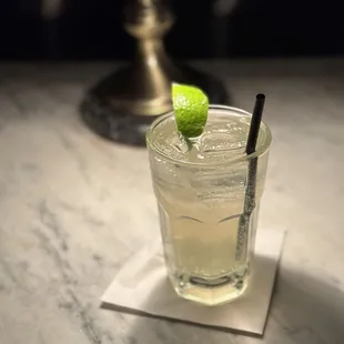 a glass of lemonade with a lime on the rim