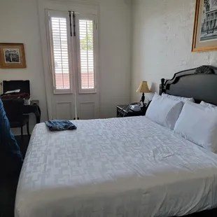 A comfortable bed and doors to the outside balcony that is shared with the next room.