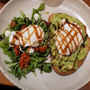 Avocado toast with poached eggs and salad