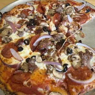a pizza with pepperoni, mushrooms, and onions