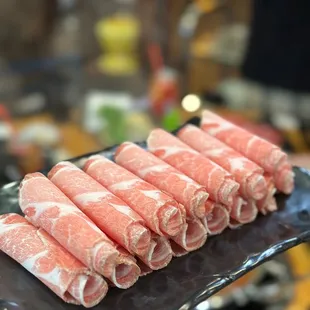 a person holding a plate of raw meat