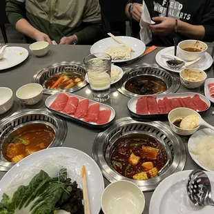 Our spread! They had a variety of broths. TL - Tomyum, TR &amp;LL - Tomato, LR - spicy broth. My favorite.