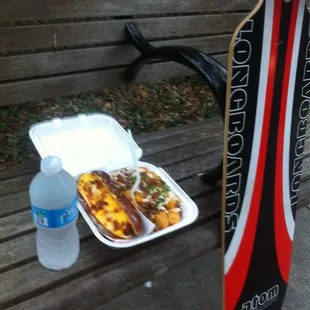 A day in the park with a bacon wrapped Nathan's hotdog and Hot Mess Tots, complete wit a bottle of water and my trusty lonngoard