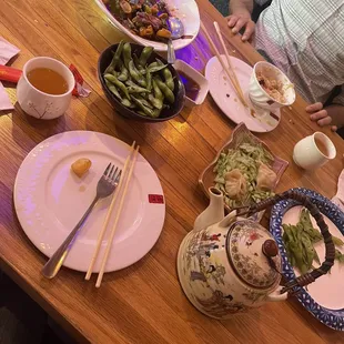 a wooden table with plates of food on it