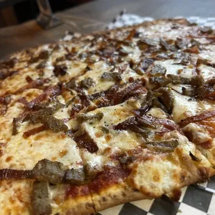 a pizza on a checkered tablecloth