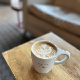 a cup of coffee on a wooden table