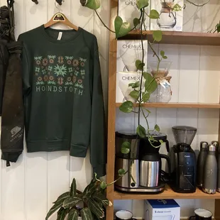 Merch for sale: Houndstooth sweatshirt and coffee accoutrements.