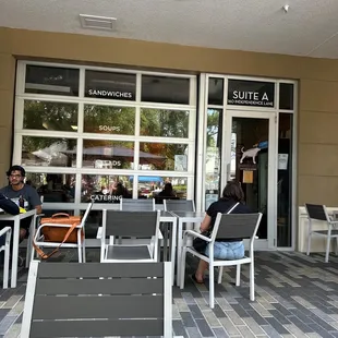two people sitting outside of a restaurant