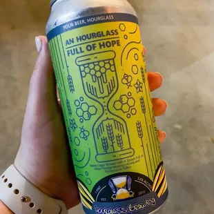 a hand holding a can of beer