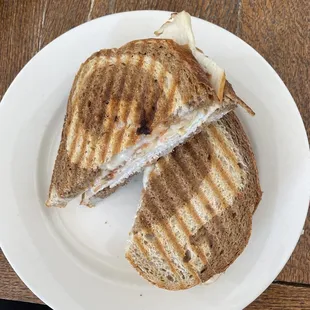 a grilled sandwich cut in half on a plate