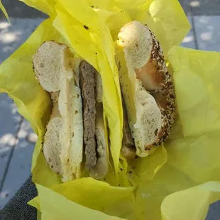 a person holding a bagel sandwich
