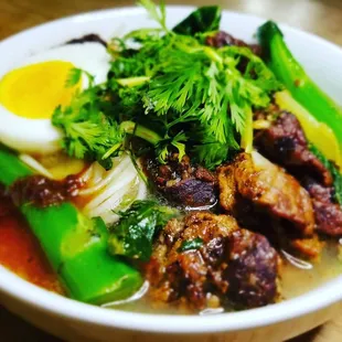 a bowl of soup with meat and vegetables