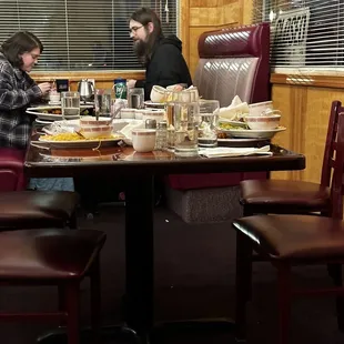 More plates and glasses and bowls stacked from other tables.