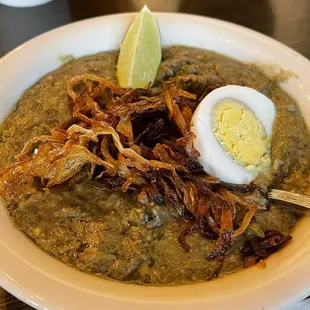 a bowl of soup with a hard boiled egg