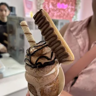 a hand holding a cup of ice cream