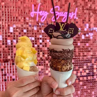 two people holding up ice cream cones