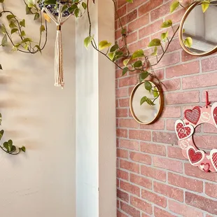 a brick wall with mirrors and a plant